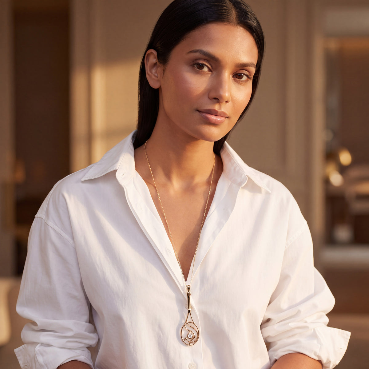 Woman wearing a yellow gold tennis racket pendant necklace with a diamond accent