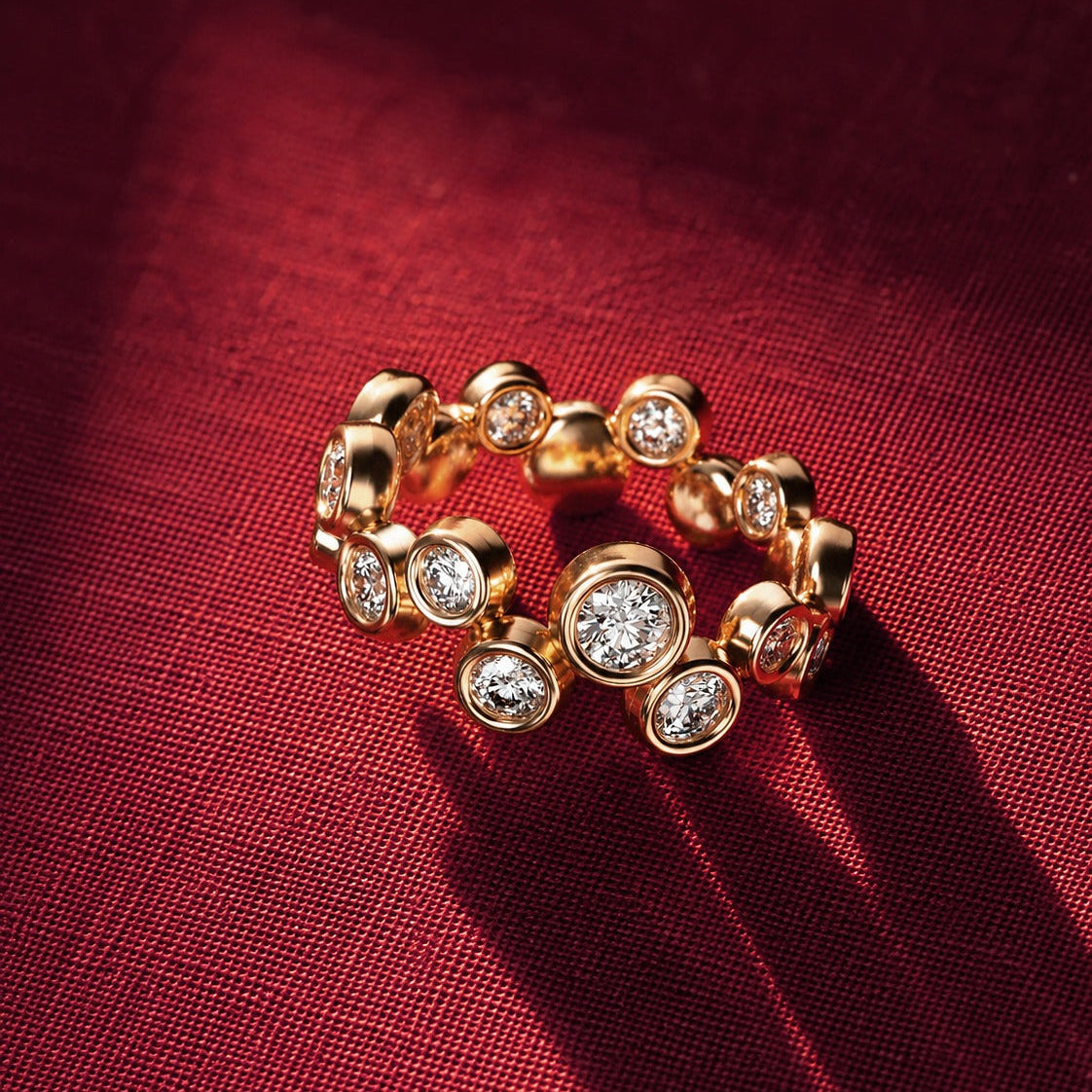 Yellow gold diamond bubble ring with round bezel-set diamonds in alternating sizes
