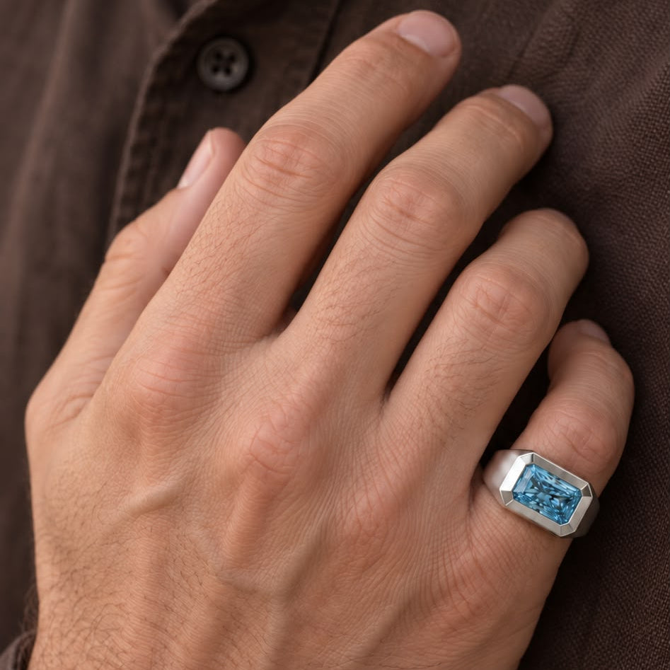 top view of a men’s blue diamond signet ring with a beveled bezel setting on hand