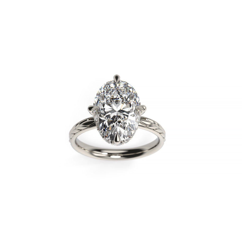 Front view of a white gold oval diamond hidden halo engagement ring with compass prongs and a spikelet-inspired shank.
