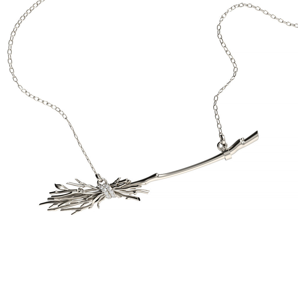 Front view of a white gold witch broom diamond pendant necklace with branch-like sculptural details, a curved handle, and diamond-accented wrap.