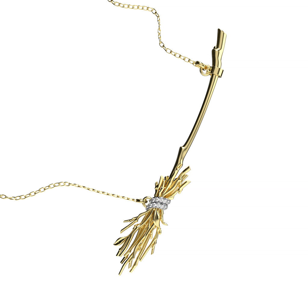 Angled view of a yellow gold witch broom diamond pendant necklace with branch-like sculptural details, a curved handle, and diamond-accented wrap.