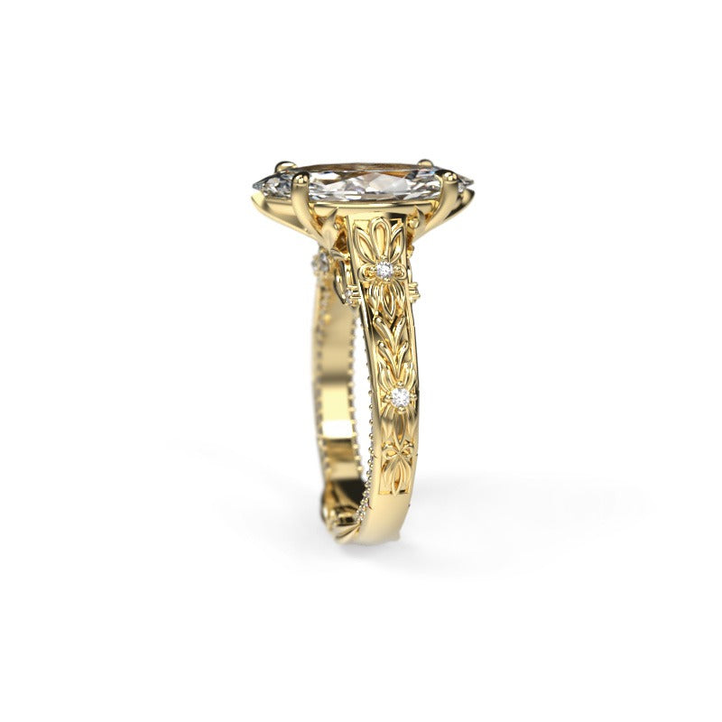Narrow side view of a yellow gold marquise engagement ring showing the centre diamond setting and diamond-set band.