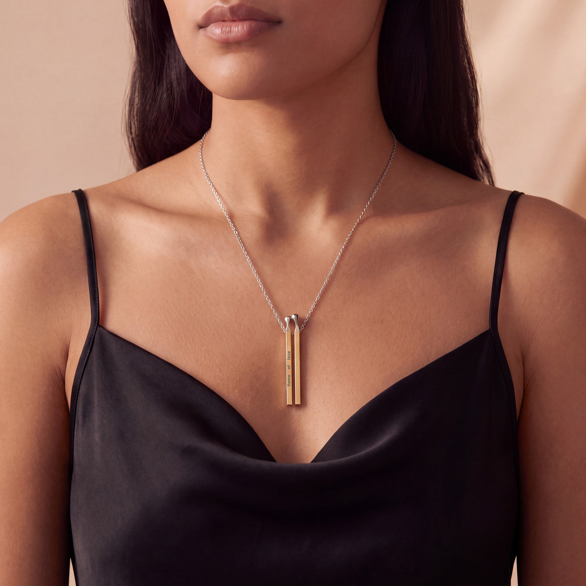 Woman wearing a two-tone yellow and white gold matchstick pendant necklace