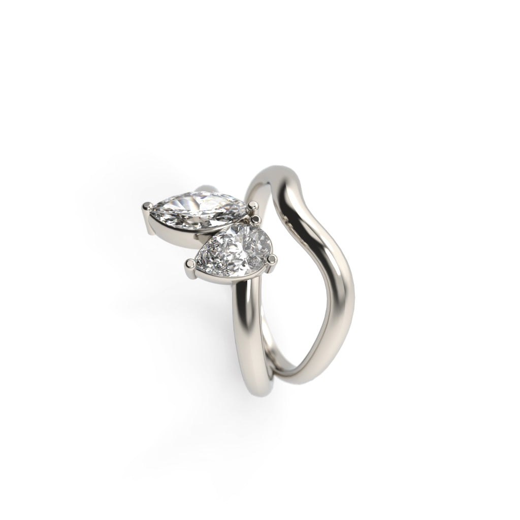 Side view of a white gold toi et moi ring with marquise and pear-shaped diamonds in a flowing sculptural band.