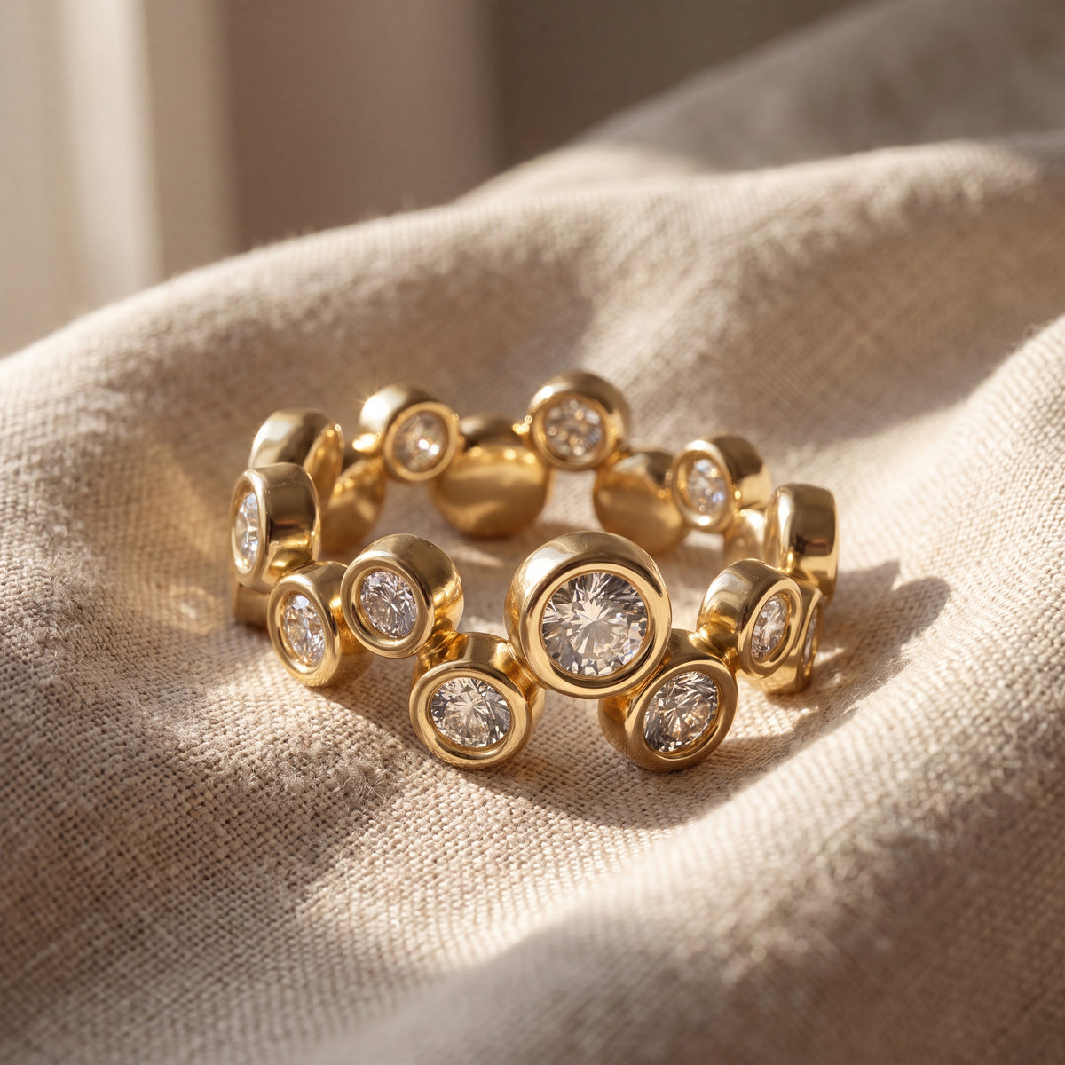 Yellow gold Bubble Bezel diamond ring with multiple round bezel-set diamonds, shown in warm natural light.